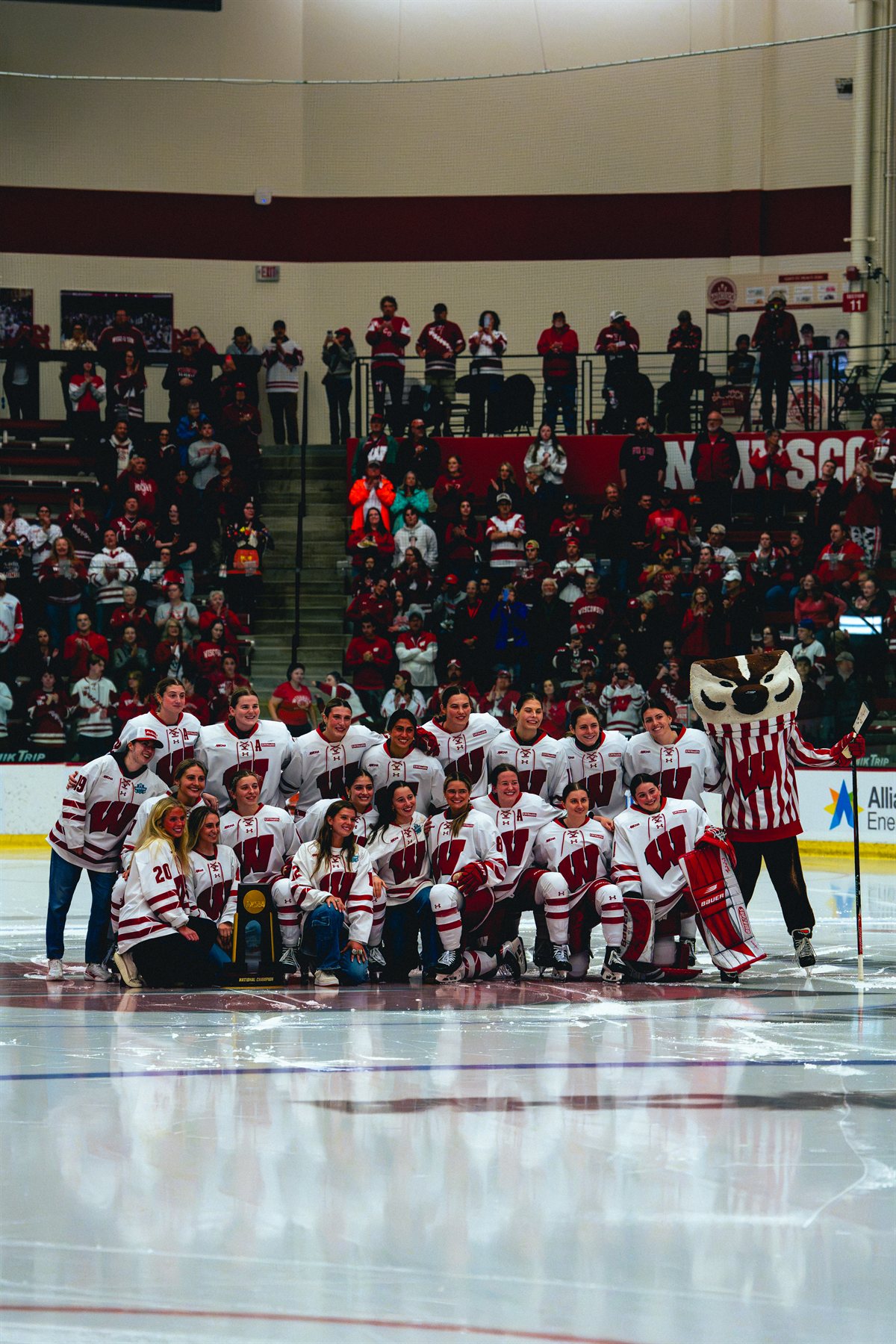 Wisconsin women's hockey team posing together on the ice