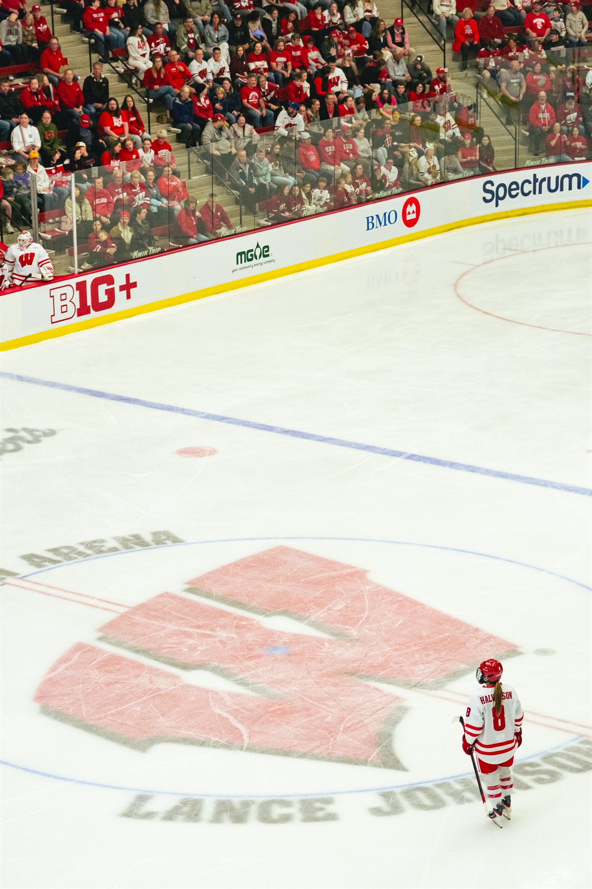 Hannah Halverson skating near the Wisconsin logo at center ice