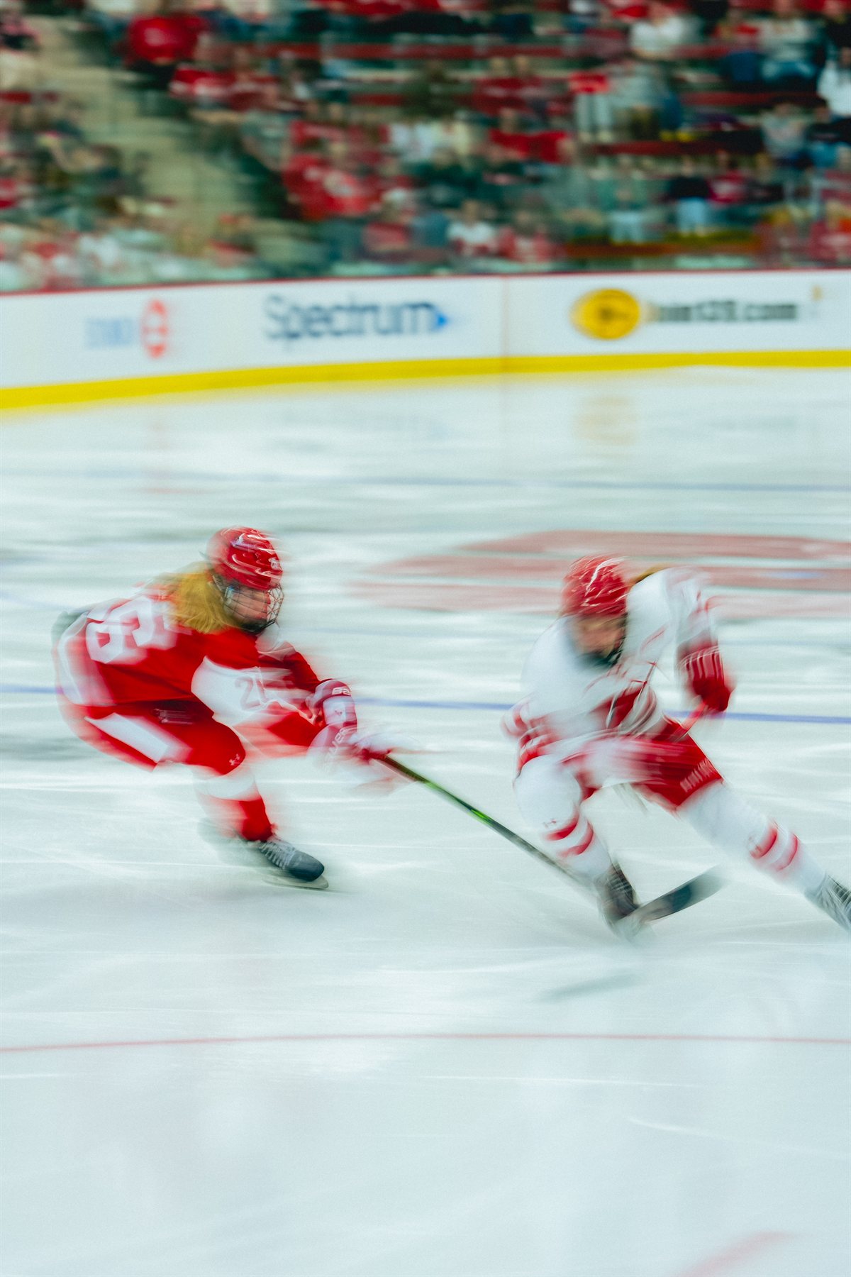 Motion-blurred hockey players skating across the ice