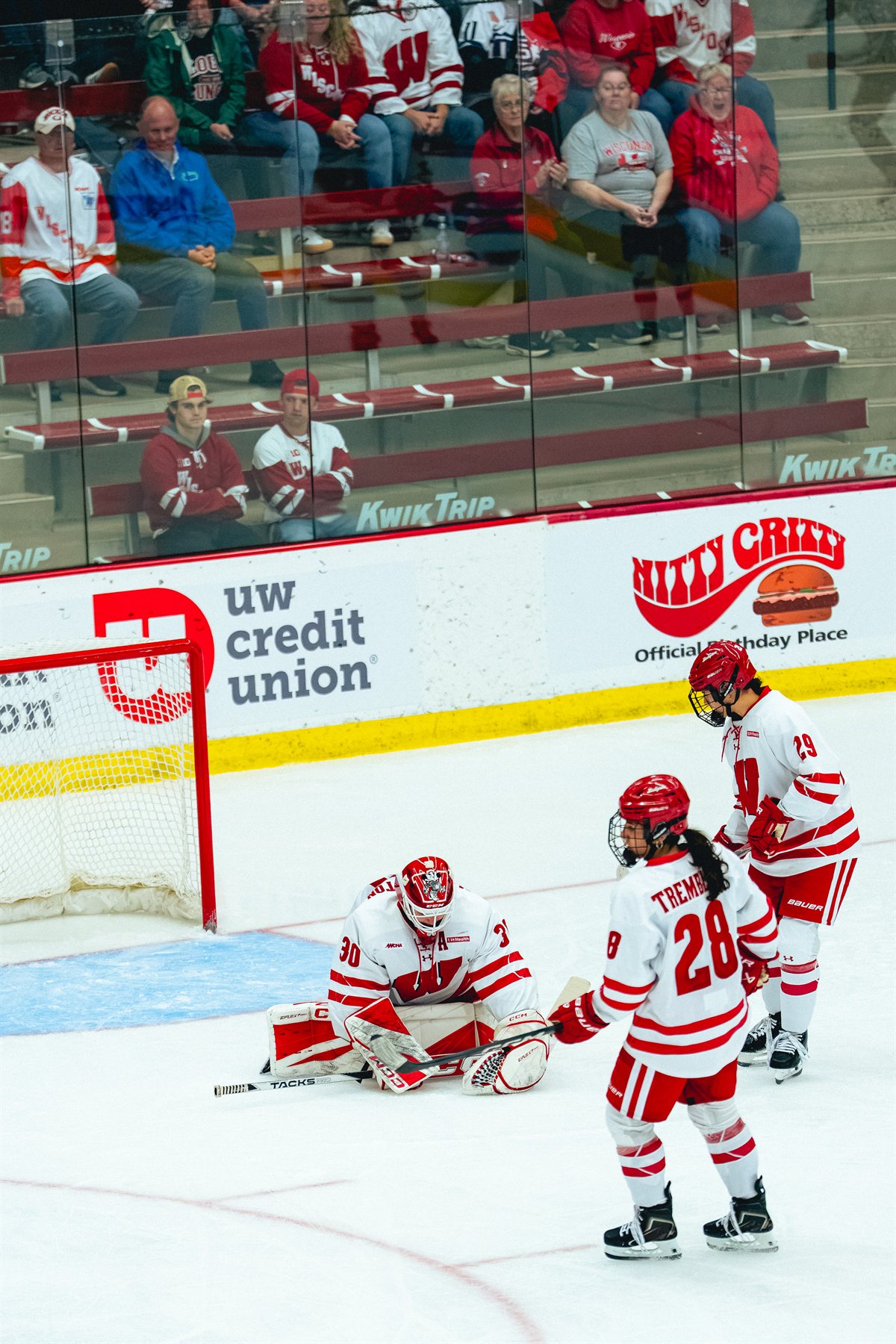 Wisconsin players gathered near their goalie on the ice