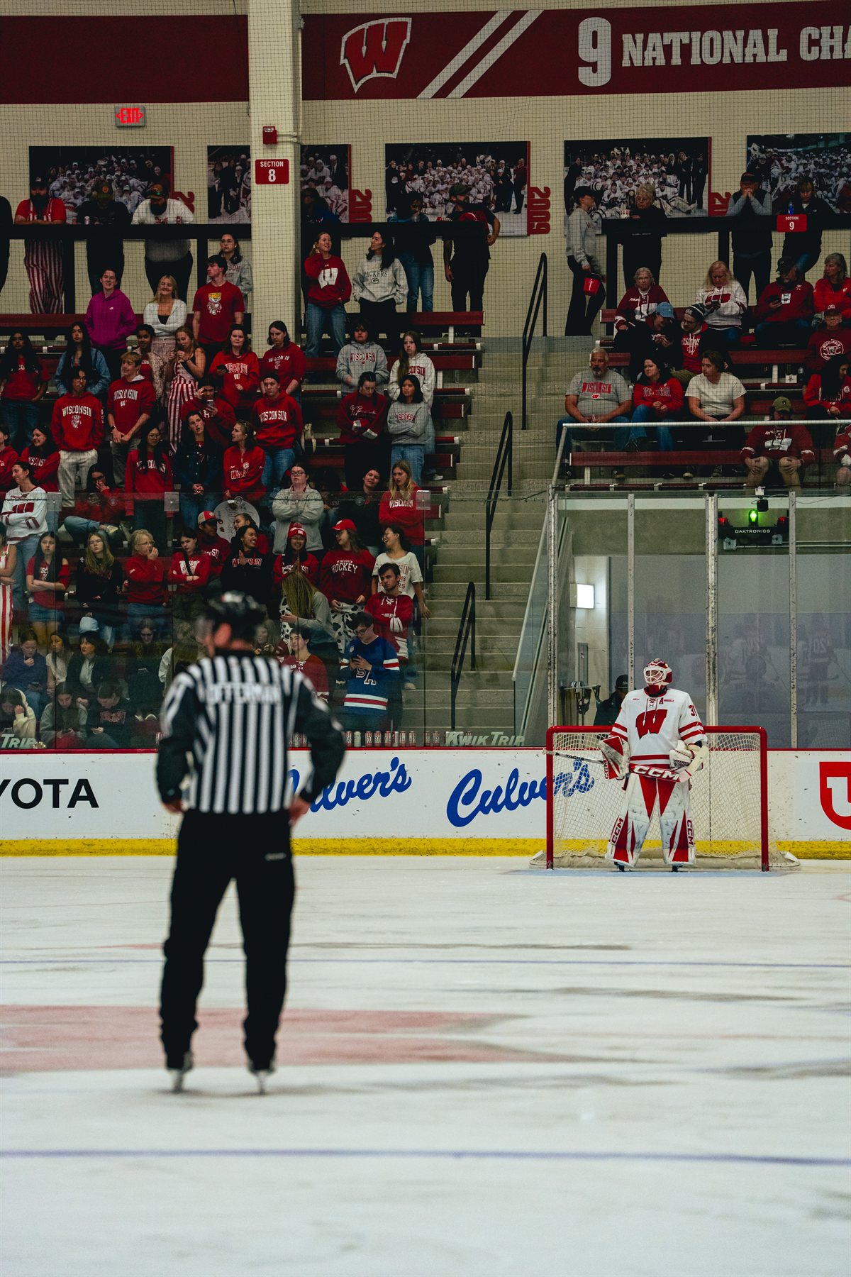 Ava McNaughton standing in the Wisconsin goal with a referee in the foreground