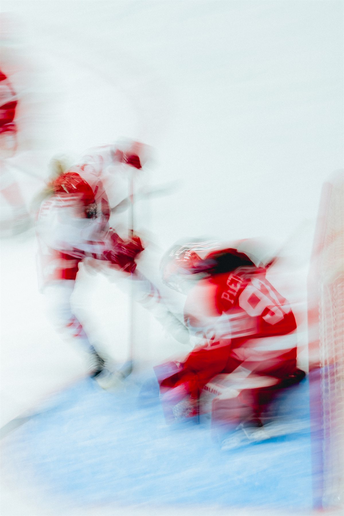 Motion-blurred Wisconsin and Boston University players battling near the goal